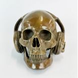 An amusing bronze figure of a skull wearing headphones, H. 16cm, W. 19cm.