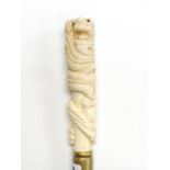 An ornately carved bone handled walking stick, cane L. 99cm, handle L. 15cm.