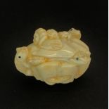 A Japanese signed bone figure of frogs playing in a shell, signed. W. 4.5 x 4cm.