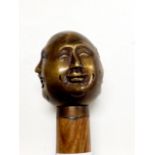 A four faced bronze Buddha walking stick, L. 92cm.