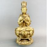 A Tibetan gilt bronze figure of a Goddess seated on a lotus throne, H. 29cm.