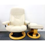 A Stressless Ekornes reclining armchair on a revolving base with matching stool, H. 102cm.