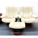 A pair of Stressless Ekornes reclining armchairs on revolving bases, one with matching stool, H.