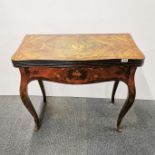 An inlaid folding games table with floral decoration and brass feet, folded 84 x 79 x 43cm. Slightly