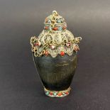 A Tibetan white metal and stone set mounted carved yak horn snuff bottle, H. 8.5cm.