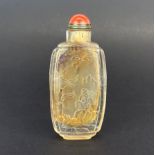 A Chinese Peking glass clear snuff bottle with embossed decoration and hardstone stopper. Snuff