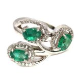 A 925 silver ring set with oval cut emeralds and white stones, (O).