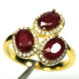 A gold on 925 silver ring set with oval cut rubies and white stones, (N).
