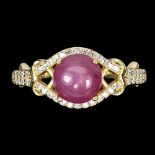 A matching gold on 925 silver ring set with a cabochon cut ruby and white stones, (P).
