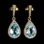 A pair of gold on 925 silver drop earrings set with pear cut blue topaz and white stones, L. 2.2cm.
