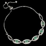 A 925 adjustable bracelet set with oval cut emeralds and white stones.