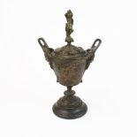 A 19th century relief decorated bronze urn and cover decorated with classical scenes, H. 29cm.