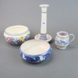 A group of four Poole pottery items, candlestick H. 24cm. Small chip restoration on candlestick.