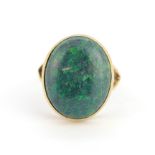 A yellow metal ring (tested minimum 9ct gold) set with a large oval cabochon sugar opal, stone