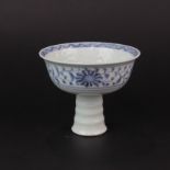 A Chinese hand painted porcelain stem cup with relief decoration of cranes among clouds and