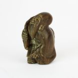 A carved signed fruitwood netsuke of a scholar, H. 5cm.