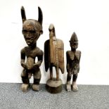 Three African carved wooden tribal figures, largest H. 61cm.