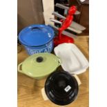 Two Le Creuset enamelled cast iron casserole dishes with an enamelled bread bin and knife stand.