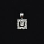 A white metal (tested approx. 18ct) pendant set with a brilliant cut diamond in a square setting