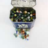 A vintage tin of old glass marbles.