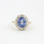 A hallmarked 18ct yellow and white gold cluster ring set with a large Ceylon sapphire surrounded