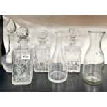 Three cut crystal decanters, a further decanter and two carafes.