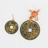 Two Chinese bronze coin amulets.