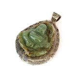 An early 20th century white metal (tested silver) mounted carved green and russet jade pendant of