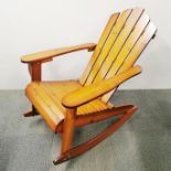 A stained pine rocking chair, H. 94cm L. 100cm.