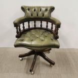 A revolving green leather button backed captain's chair on wheels, H. 87cm.