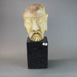 A 19th century oriental carved soapstone head standing on a lacquered wooden plinth, overall H.