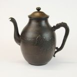 A 19th century Chinese cast bronze kettle with relief decoration of trees resembling characters
