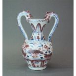 A Chinese Ming Dynasty style porcelain vase with underglaze blue and red decoration and dragon