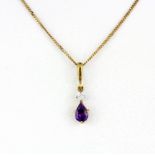 A yellow metal amethyst and diamond pendant on a hallmarked 9ct yellow gold chain, L. 44cm.