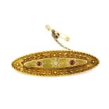 A 15ct yellow gold brooch set with an old cut diamond and rubies, L. 5cm.