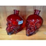 A pair of heavy red glass skull bottles,H. 16cm.