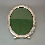 A large oval sterling silver photograph frame c. 1920's, W. 24cm. H. 32cm.