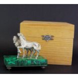 A boxed Russian .84 silver figure of two horses on a malachite veneered silver base with original