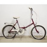 A vintage lady's Stowaway free folding bicycle.