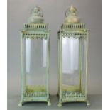 A pair of metal and glass storm lanterns, H. 63cm.
