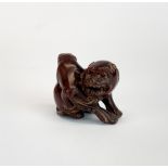 A signed fruitwood netsuke of a liondog and pup, H. 3.5cm.