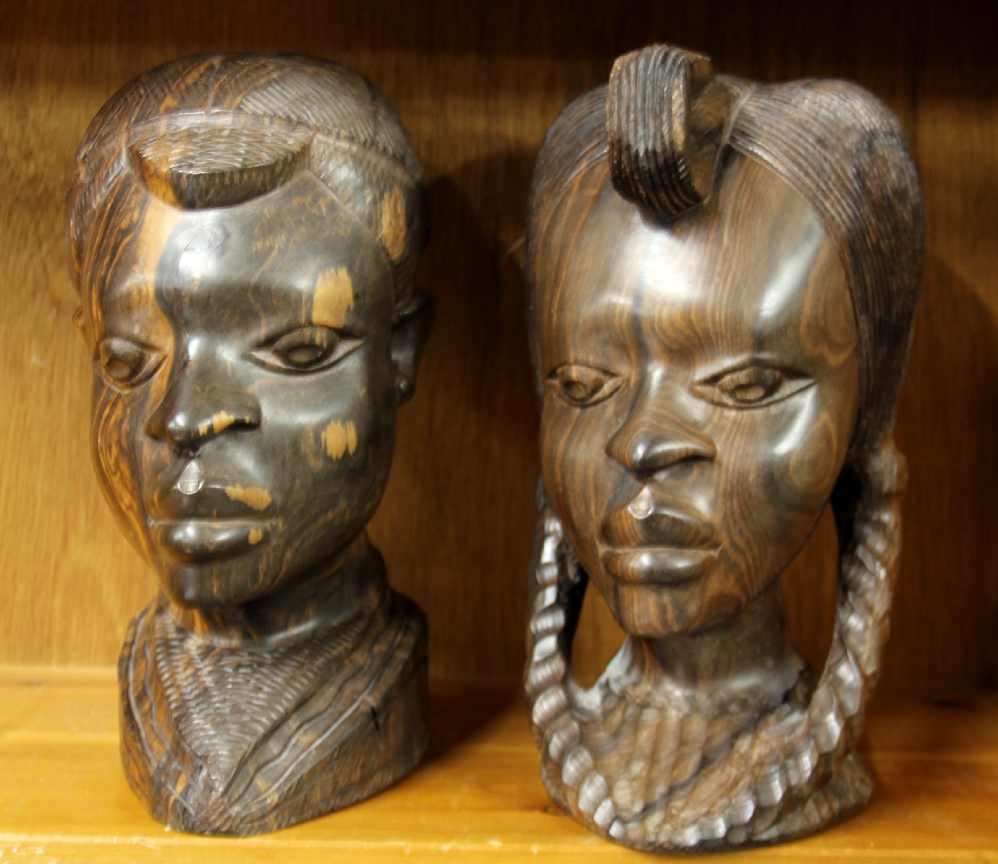 A pair of African carved figured ebony tribal busts, H. 28cm.