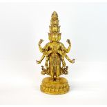 A Tibetan gilt bronze figure of a multi-arm and multi- head deity with jewelled decoration, H.