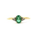 A 9ct yellow gold ring set with an oval cut emerald and diamonds, (S).