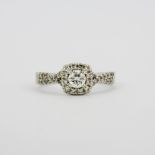 A 9ct white gold cluster ring set with a large brilliant cut diamond, surrounded by diamonds and