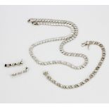A 925 silver jewellery suite set with white stones including a necklace, bracelet and drop