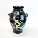 A Chinese blue glazed stoneware vase with tiger head handles and incised decoration of a dragon,