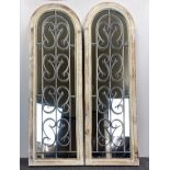 A pair of arched wood and metal garden mirrors, H. 123cm.