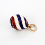 A Russian hallmarked 14ct gold and striped enamel egg pendant, L. 2.5cm.