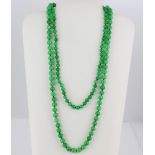 A double strand graduated jade beaded necklace with a 14ct yellow gold clasp, L. 60cm.